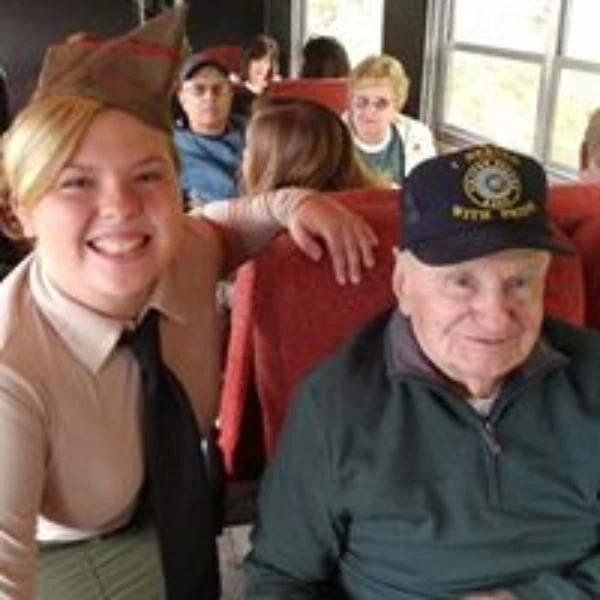 Person in costume posing with a veteran