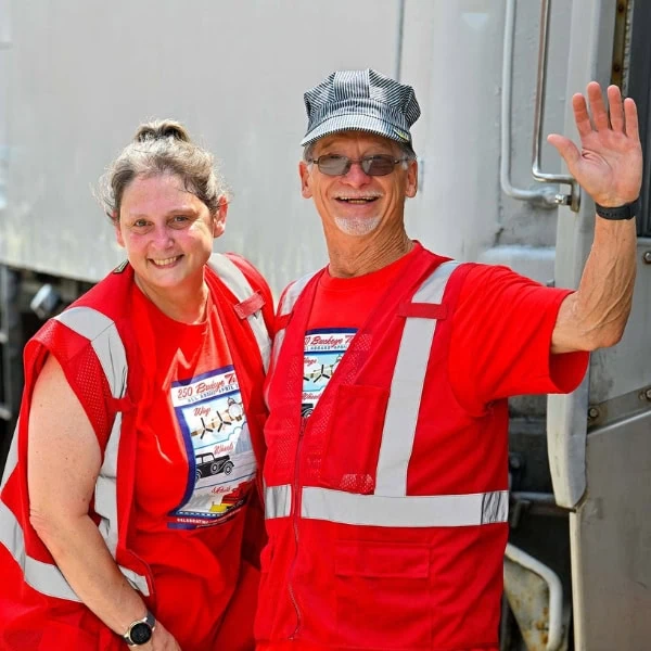 Two volunteers wearing red safety vests.